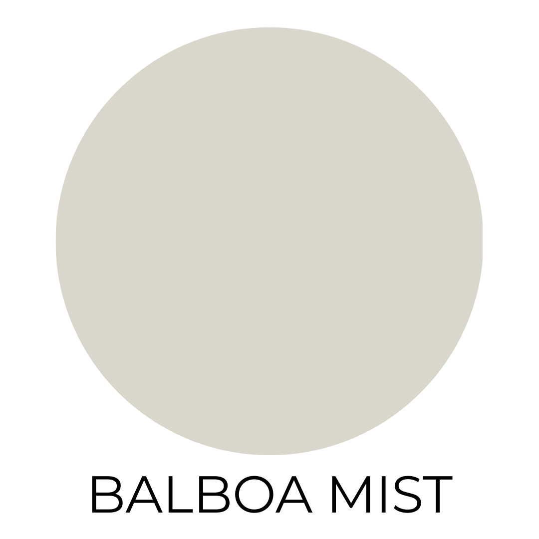 A digital paint swatch labeled “Balboa Mist” by Benjamin Moore. The swatch shows a soft, warm greige with subtle violet undertones. It’s centered in a light gray-beige circle on a white background, with the name "BALBOA MIST" written in bold, black capital letters underneath.