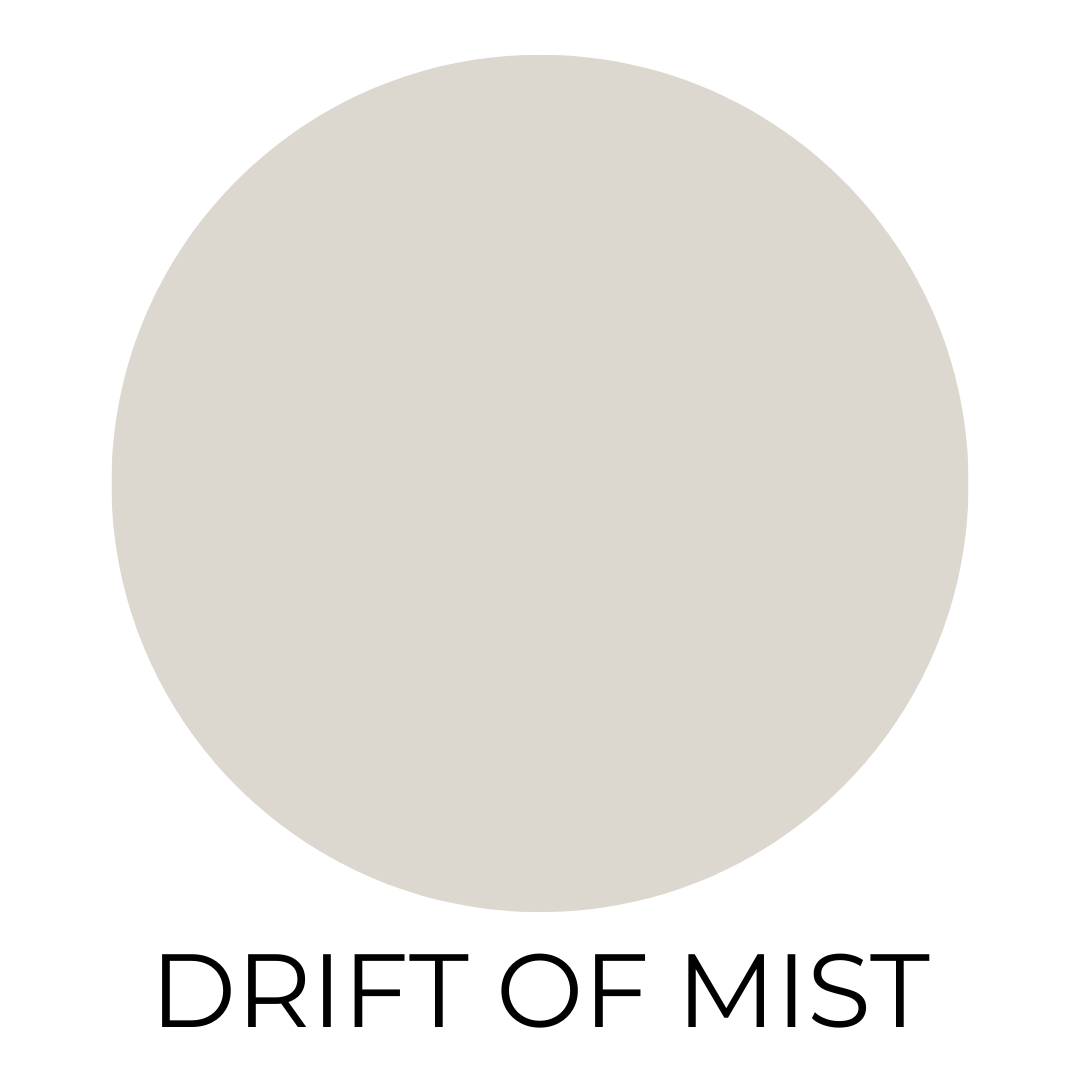 Round swatch of Sherwin Williams Drift of Mist paint, a soft light gray with warm undertones, displayed on a white background.