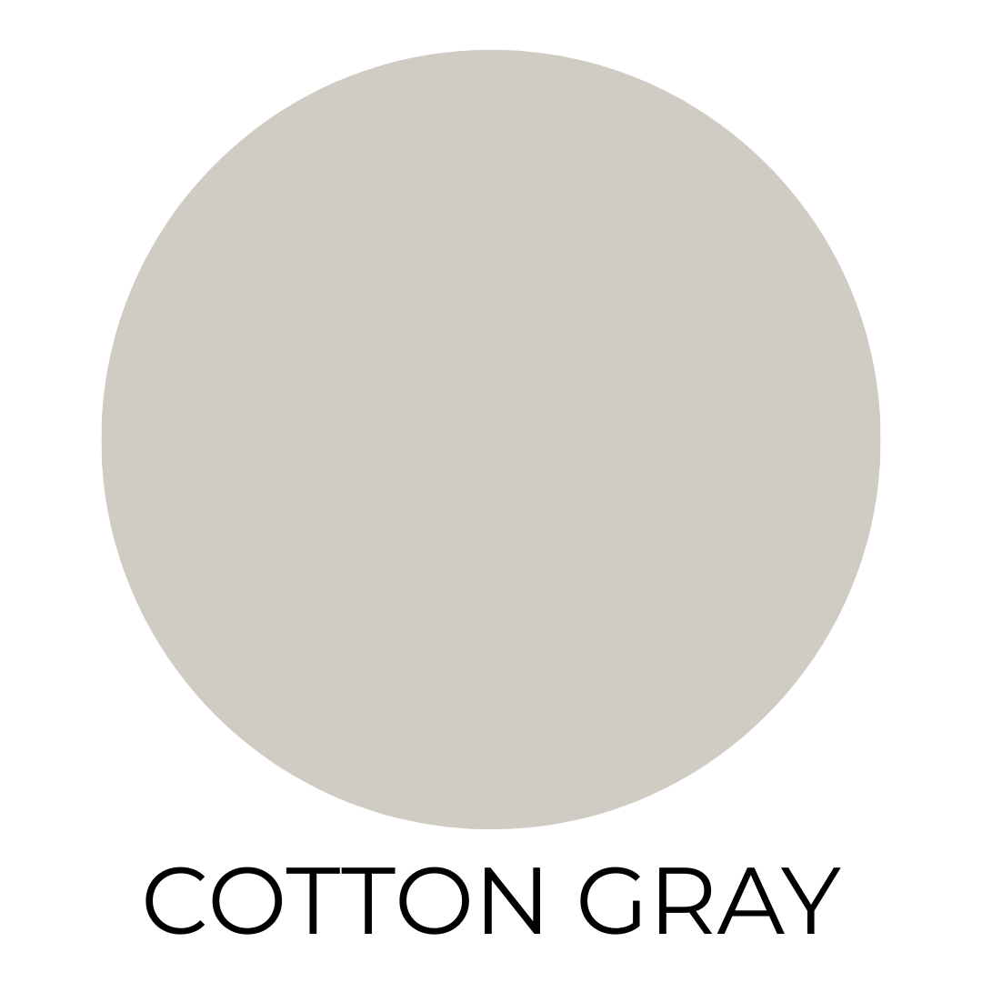 Round swatch of Behr Cotton Grey paint, a soft neutral light gray ideal for bedrooms or bathrooms, on a white background.