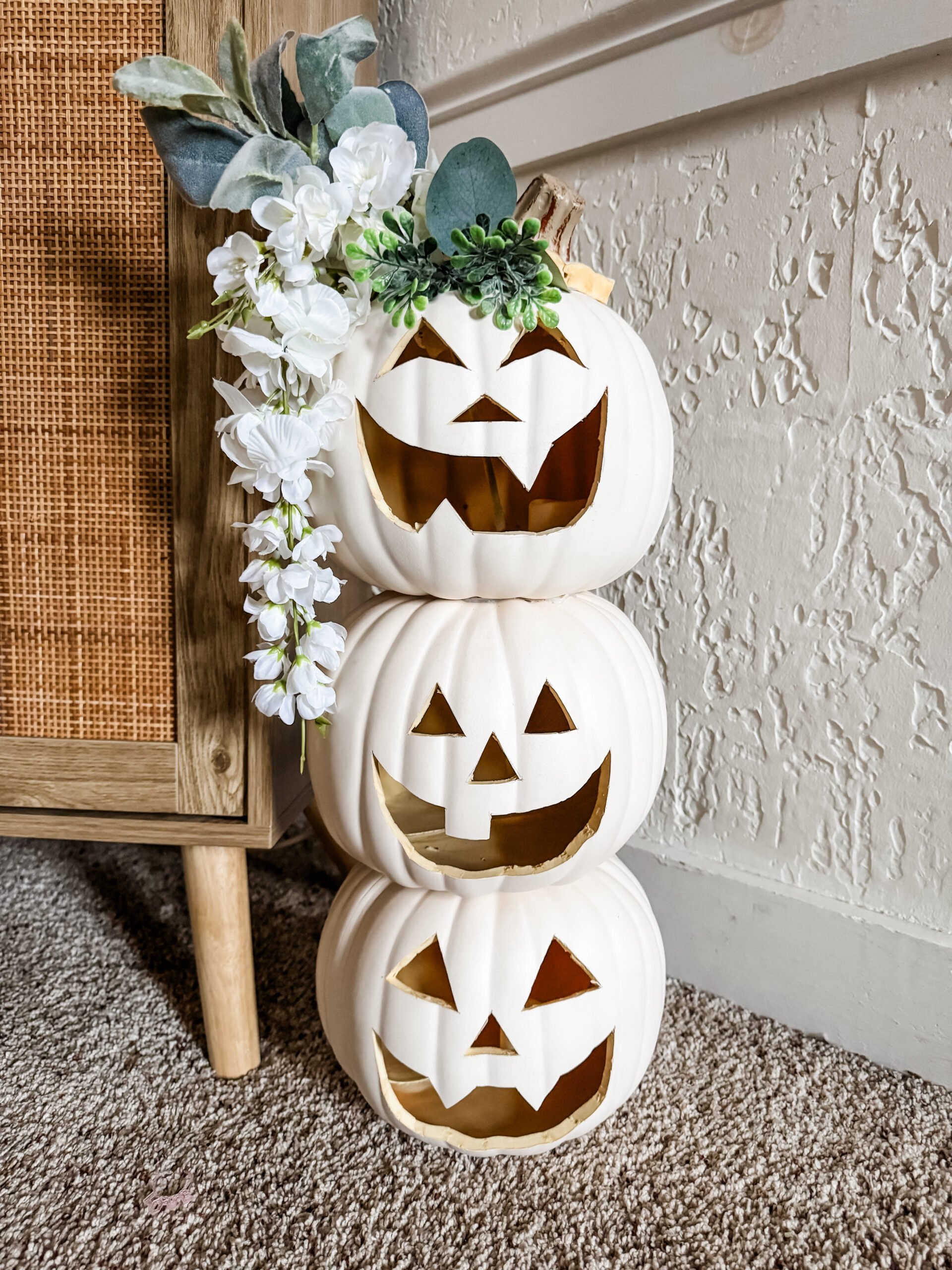 DIY neutral stacked pumpkin Halloween decor with white jack-o-lanterns and faux floral crown