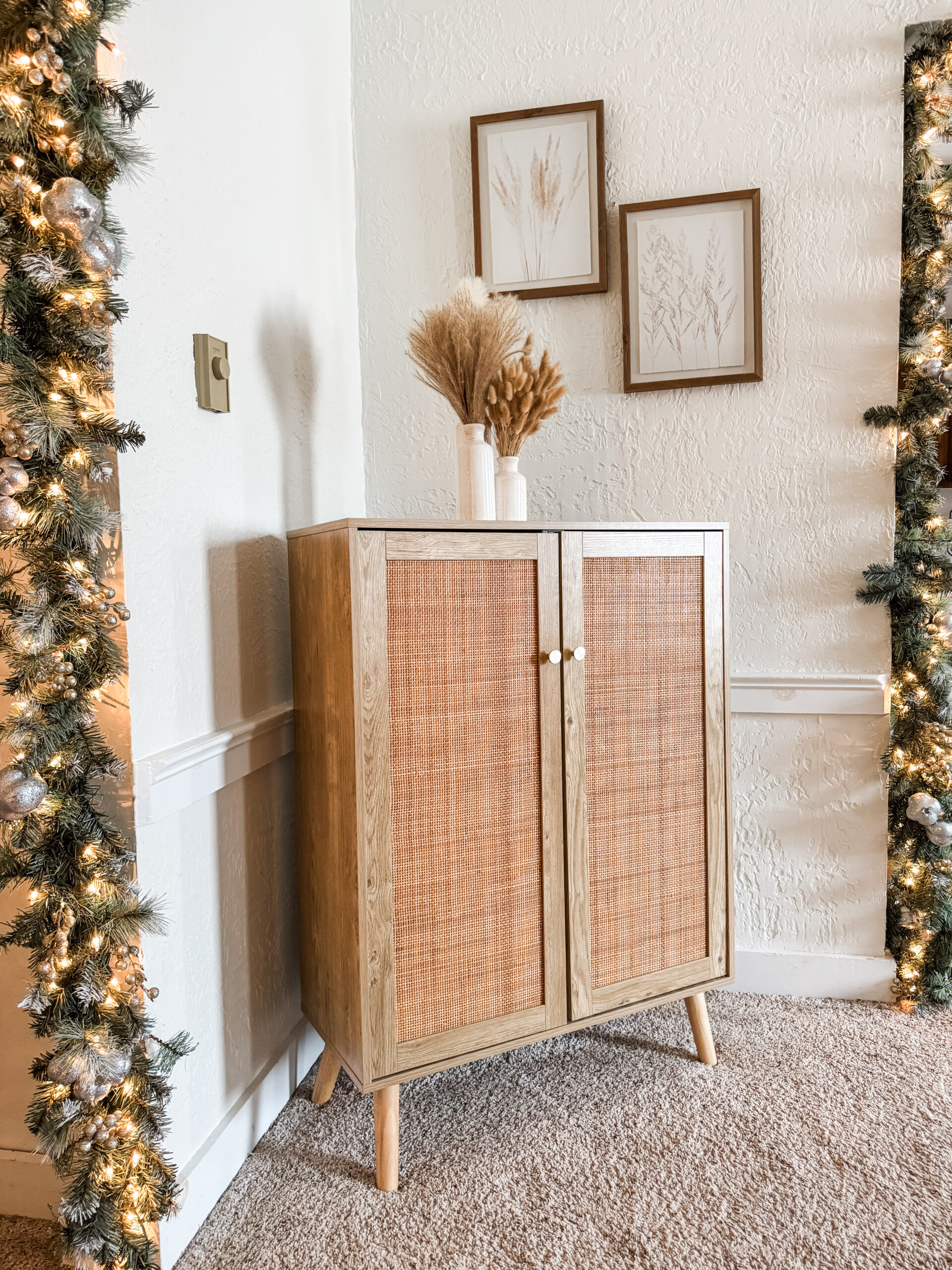 Cozy boho corner with a rattan cabinet decorated with warm wood tones and subtle Christmas accents.