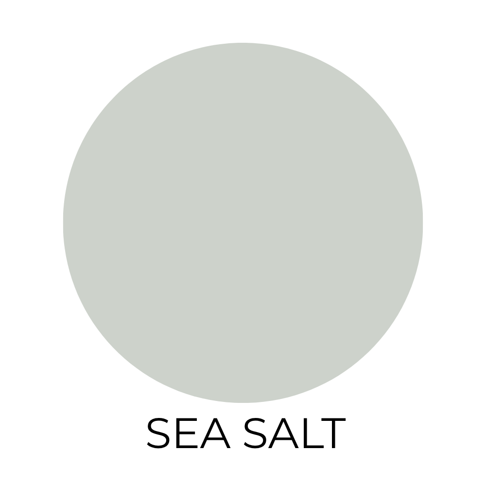 Sherwin-Williams Sea Salt paint color swatch shown as a soft blue-green with subtle gray undertones, displayed as a circular sample on a light background with the label “Sea Salt” below.