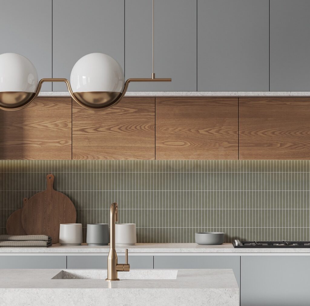 Popular kitchen backsplash idea featuring slim olive green Kit Kat tiles paired with warm wood cabinets, soft gray cabinetry, white countertops, and brass fixtures.