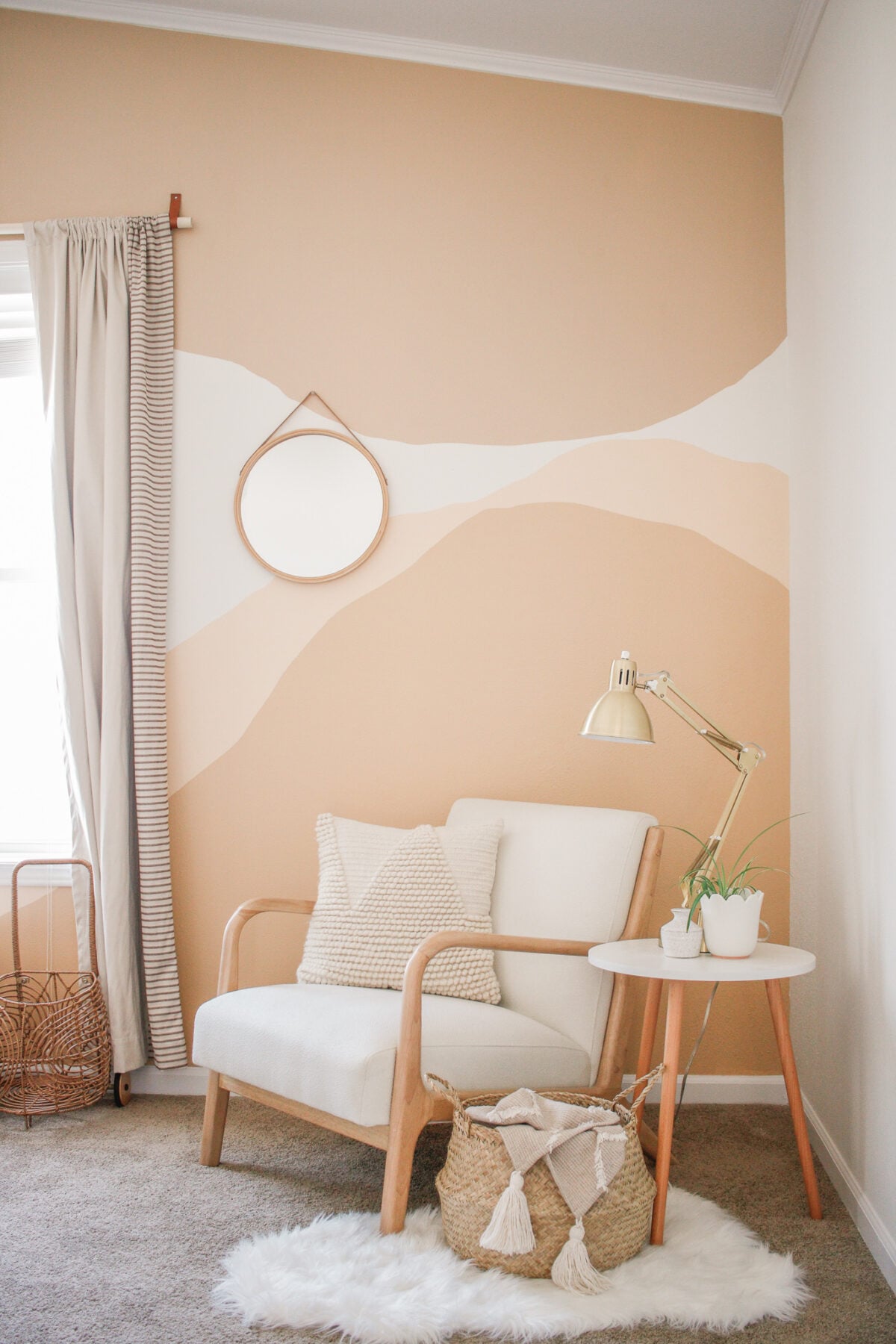 DIY painted wall mural accent wall with soft abstract shapes in warm neutral tones, styled with a cozy chair and natural decor.