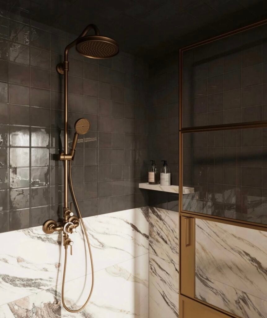 Moody luxury walk-in shower with glossy charcoal square wall tiles, dramatic white marble-look lower wall tiles with gray veining, antique brass rainfall showerhead, handheld shower fixtures, and bronze-framed glass enclosure.